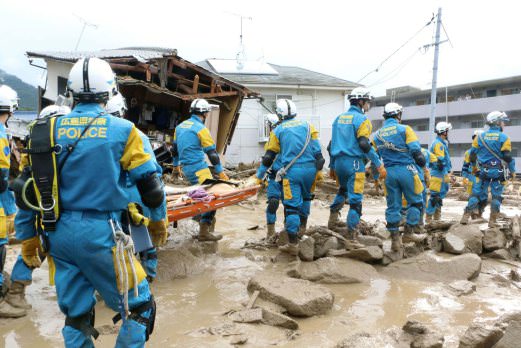 Rescue units of police officers walk during a rescue operation after a massive landslide swept through a residential area at Asaminami ward in Hiroshima, western Japan